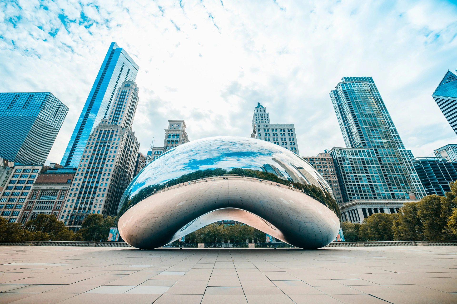 Cloud Gate in Millennium Park, Chicago reflects the city skyline and cloudy sky