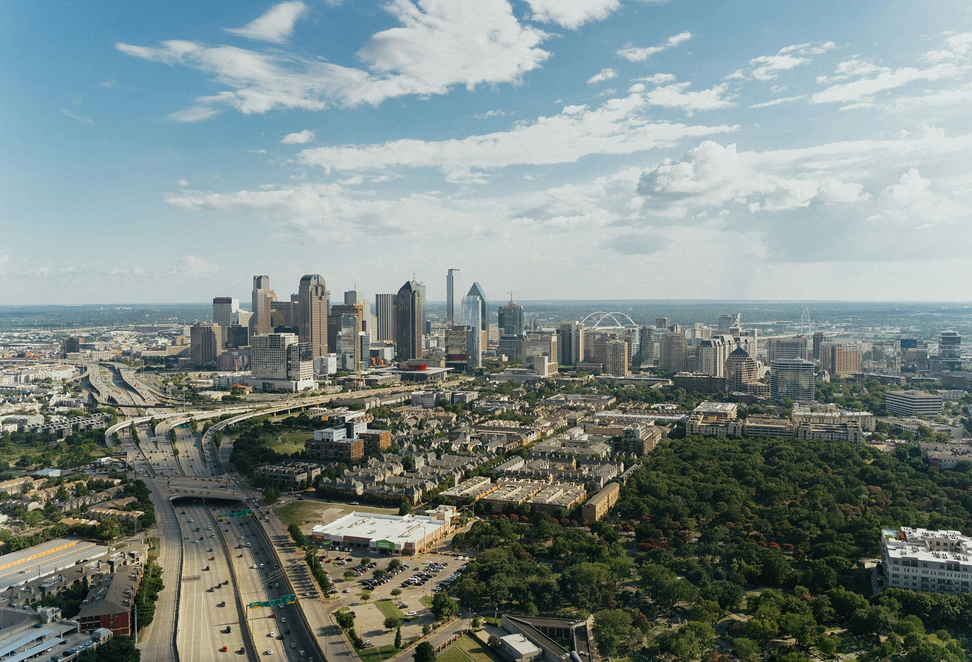 An aerial view of the Dallas, Texas skyline on a partly cloudy day
